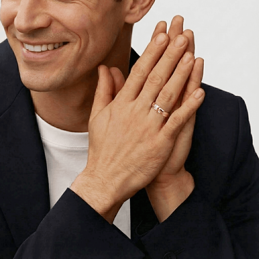 Man wearing a ring with clasped hands on a neutral background | 18K Rose Gold Natural Diamond Bezel Set 4mm Men Wedding Band - SARATTI