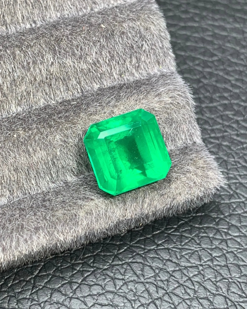 Close-up of broad step-cut facets on a Vivid Green Natural Emerald | SARATTI