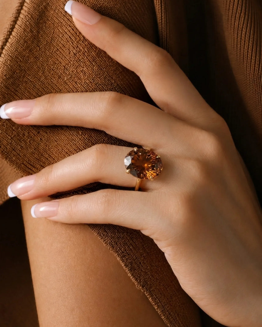 Cognac Imperial Topaz engagement ring featuring an oval center and six-petal 18K yellow gold setting | SARATTI