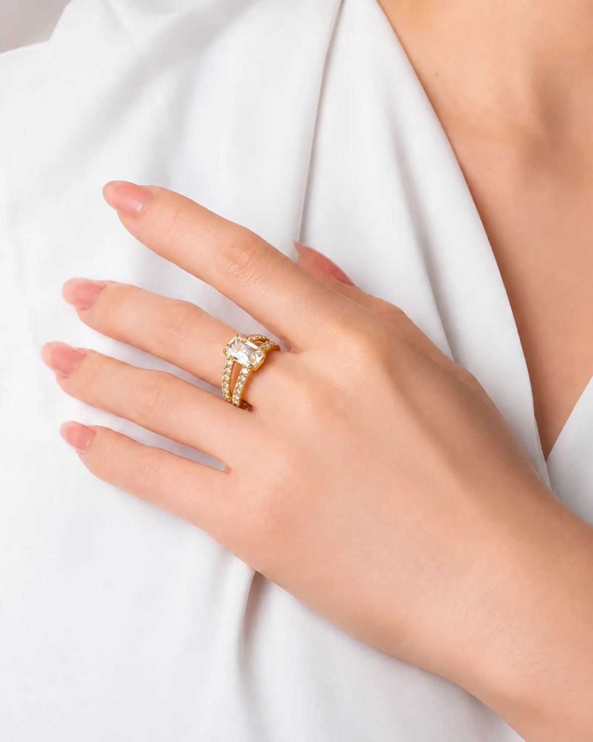 Colorless emerald-cut moissanite center with round accents in polished yellow gold | SARATTI.