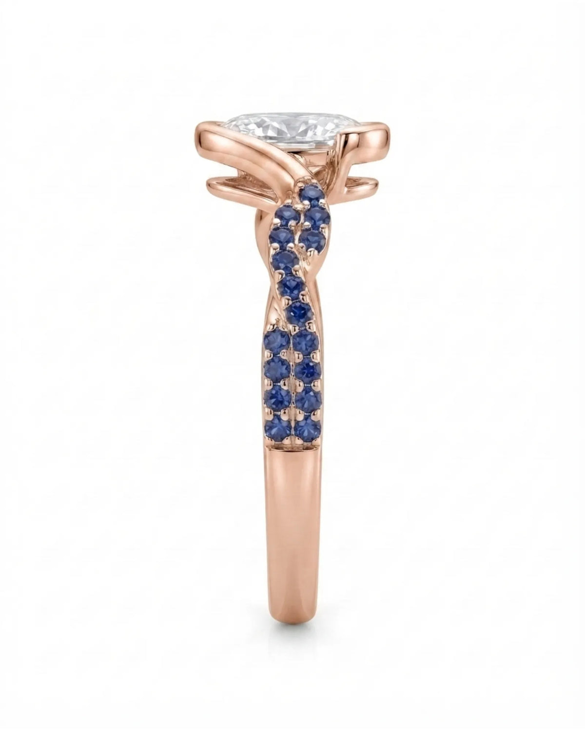 Colorless oval moissanite framed by vivid blue sapphires in polished rose gold | SARATTI