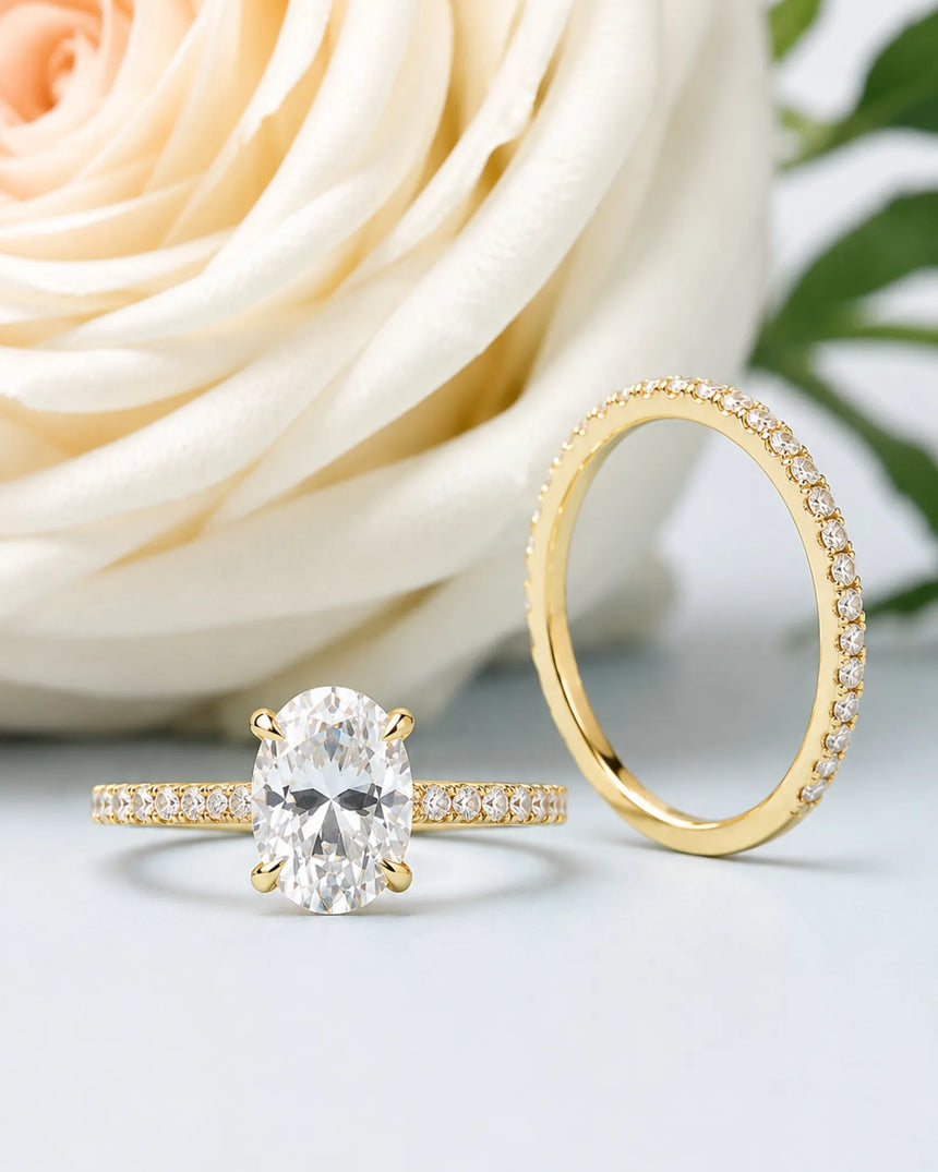 D colorless oval moissanite engagement ring with round accent stones and 18K yellow gold wedding band | SARATTI