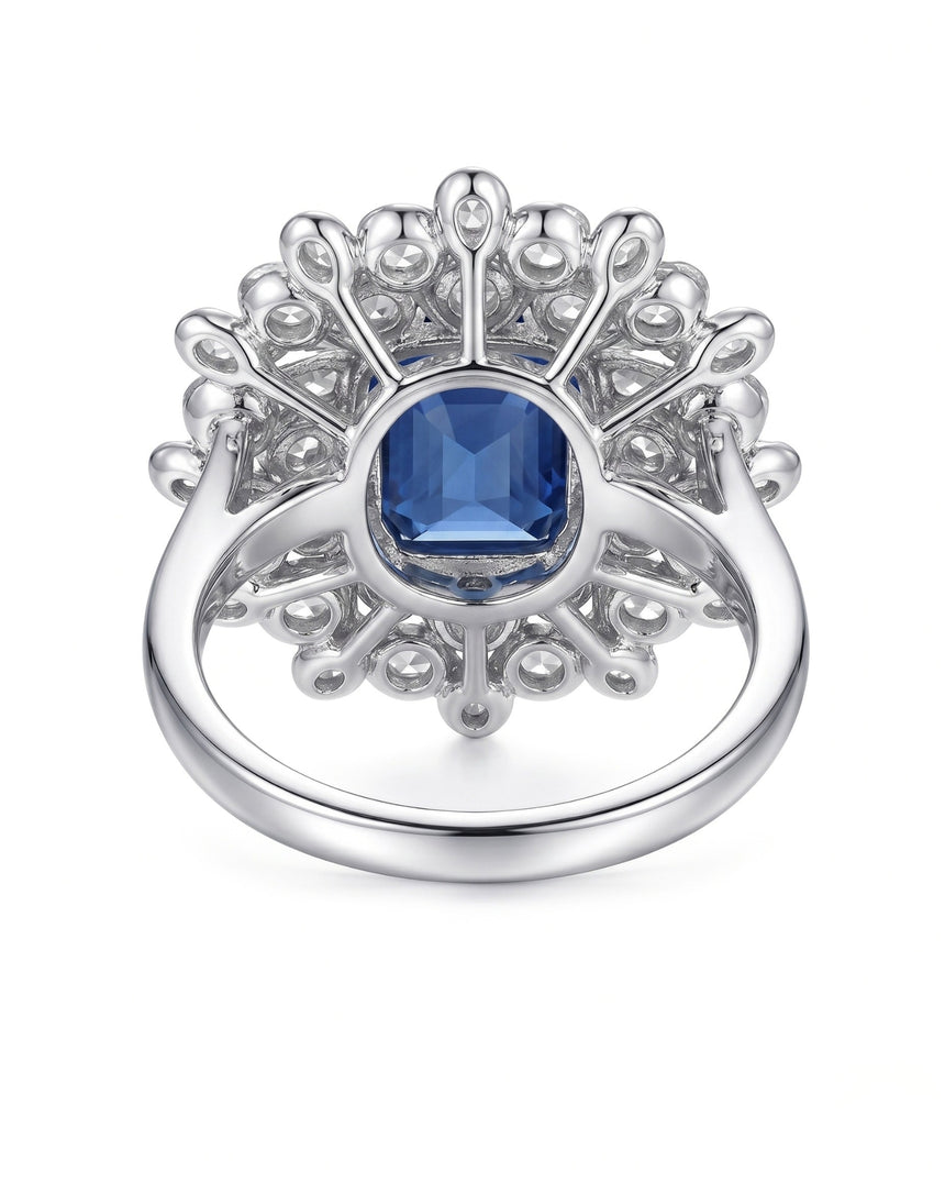 Emerald-cut royal blue sapphire ring framed by white diamonds in platinum | SARATTI