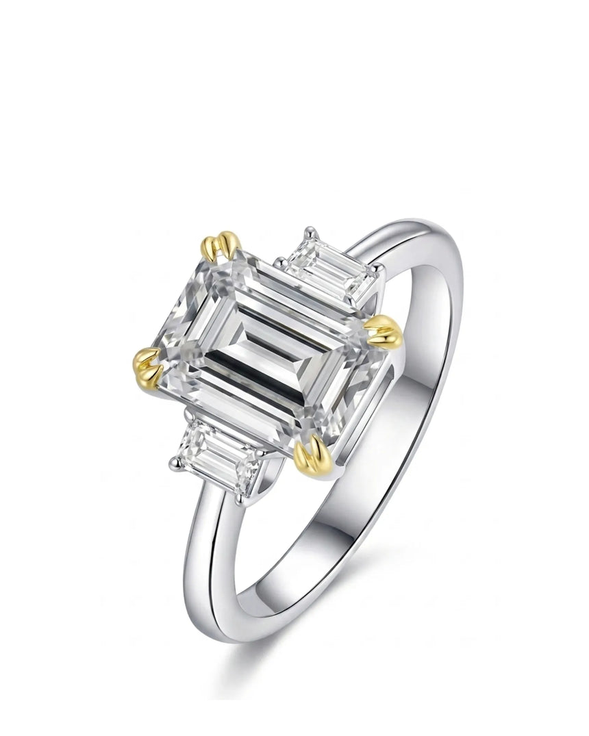Emerald cut moissanite three stone engagement ring with yellow claw prongs in two tone | SARATTI