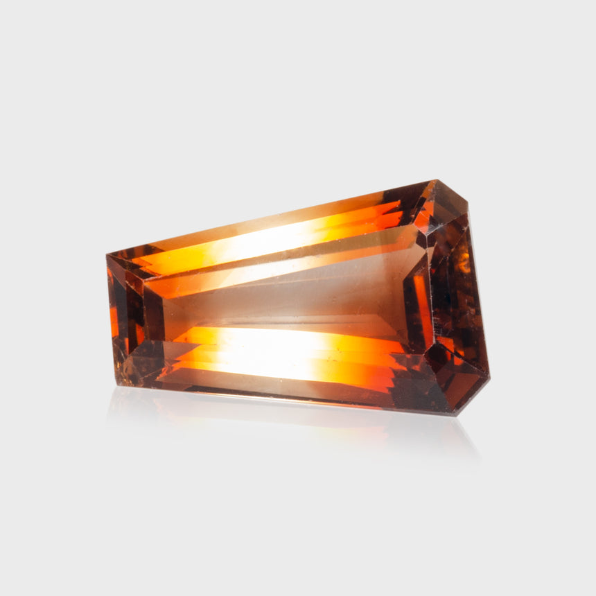 Rectangular orange gemstone on a light gray background | Imperial Topaz Gemstone - SARATTI