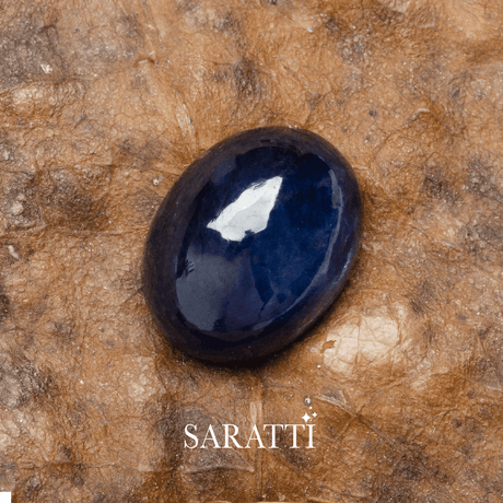 Large oval cut blue sapphire photographed on textured background | SARATTI
