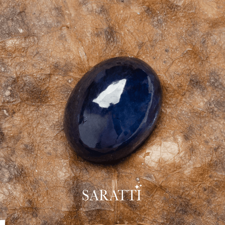 Large oval cut blue sapphire photographed on textured background | SARATTI