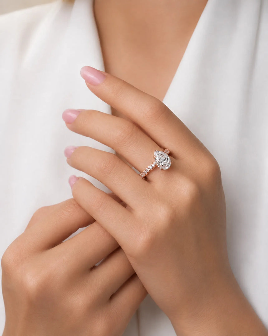 Luxury pear cut moissanite ring with detailed gallery and luminous accents in 18K rose gold | SARATTI