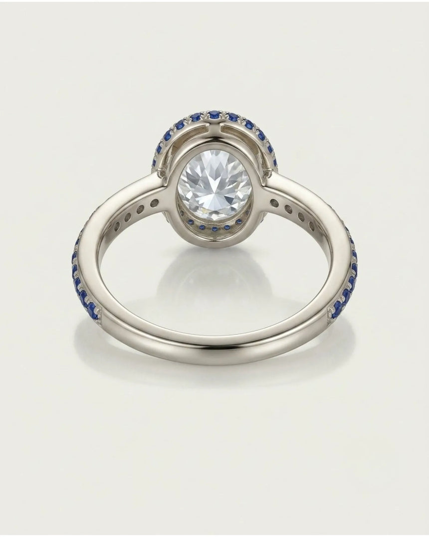 Modern oval moissanite engagement ring with blue sapphire detailing crafted in enduring platinum | SARATTI