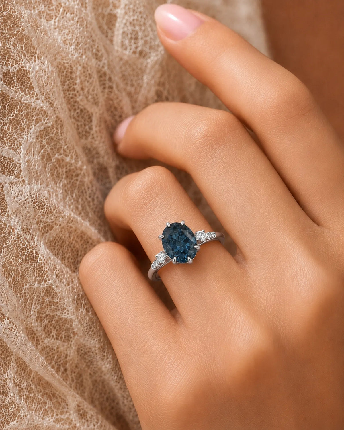 Oval blue moissanite center with colorless round side stones in 18K white gold | SARATTI
