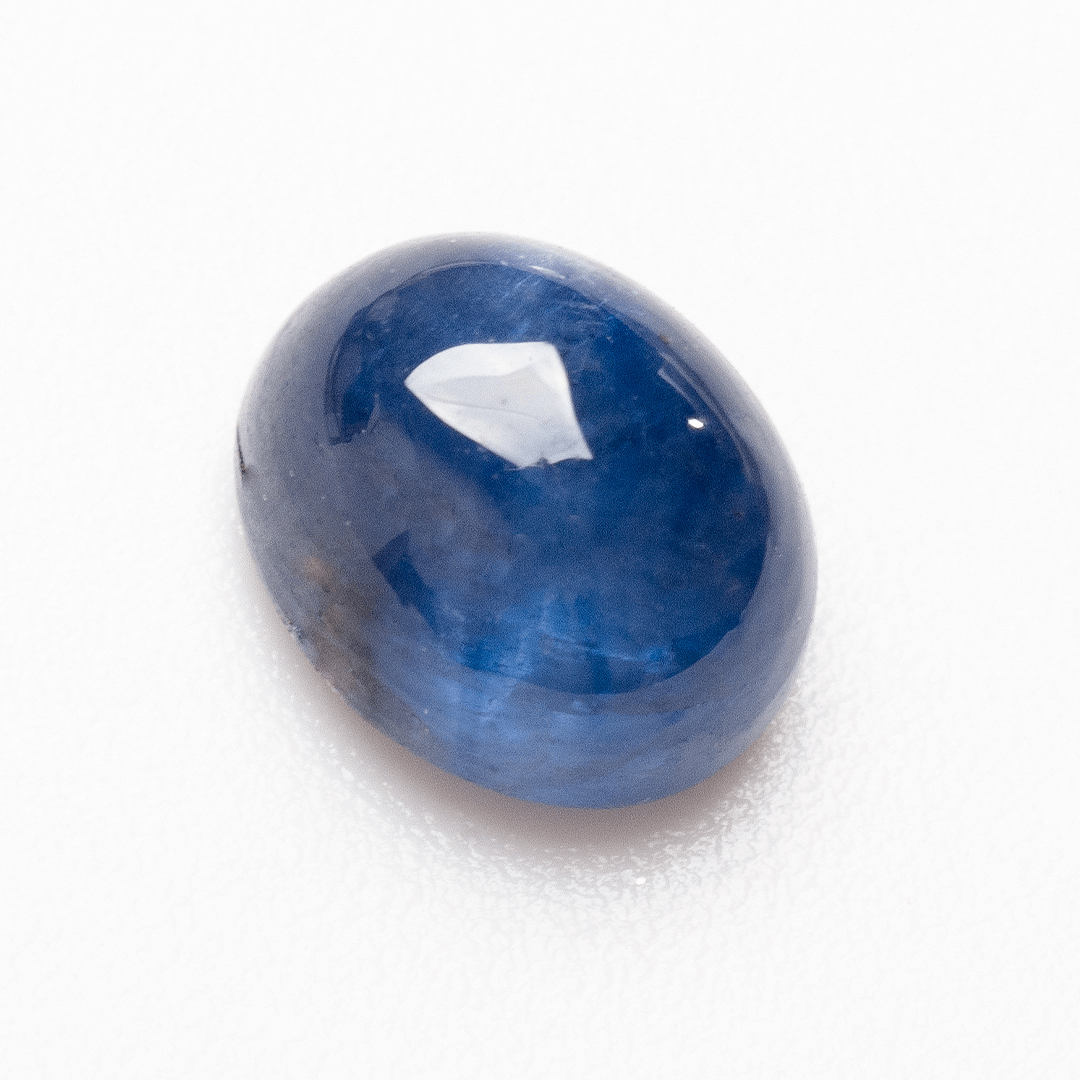 Oval cabochon blue sapphire gemstone close-up with deep royal tone | SARATTI