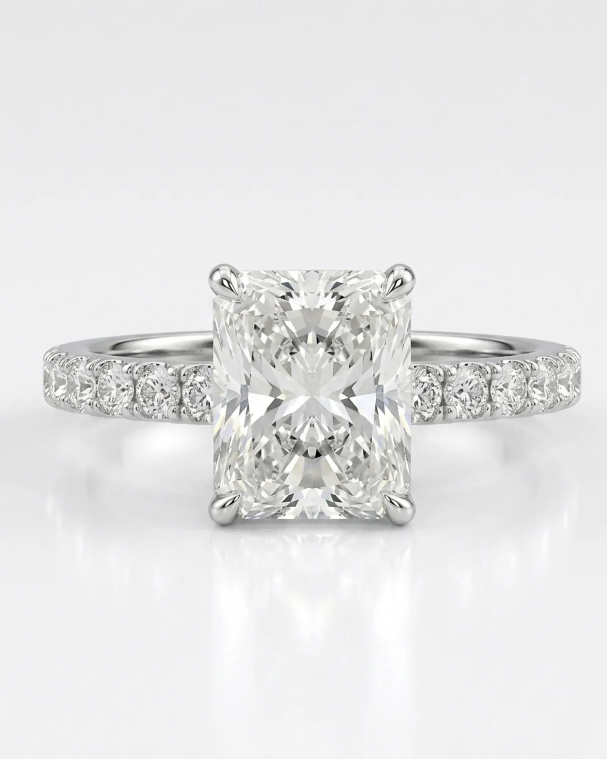 Radiant moissanite center stone ring with round side stones in platinum | SARATTI