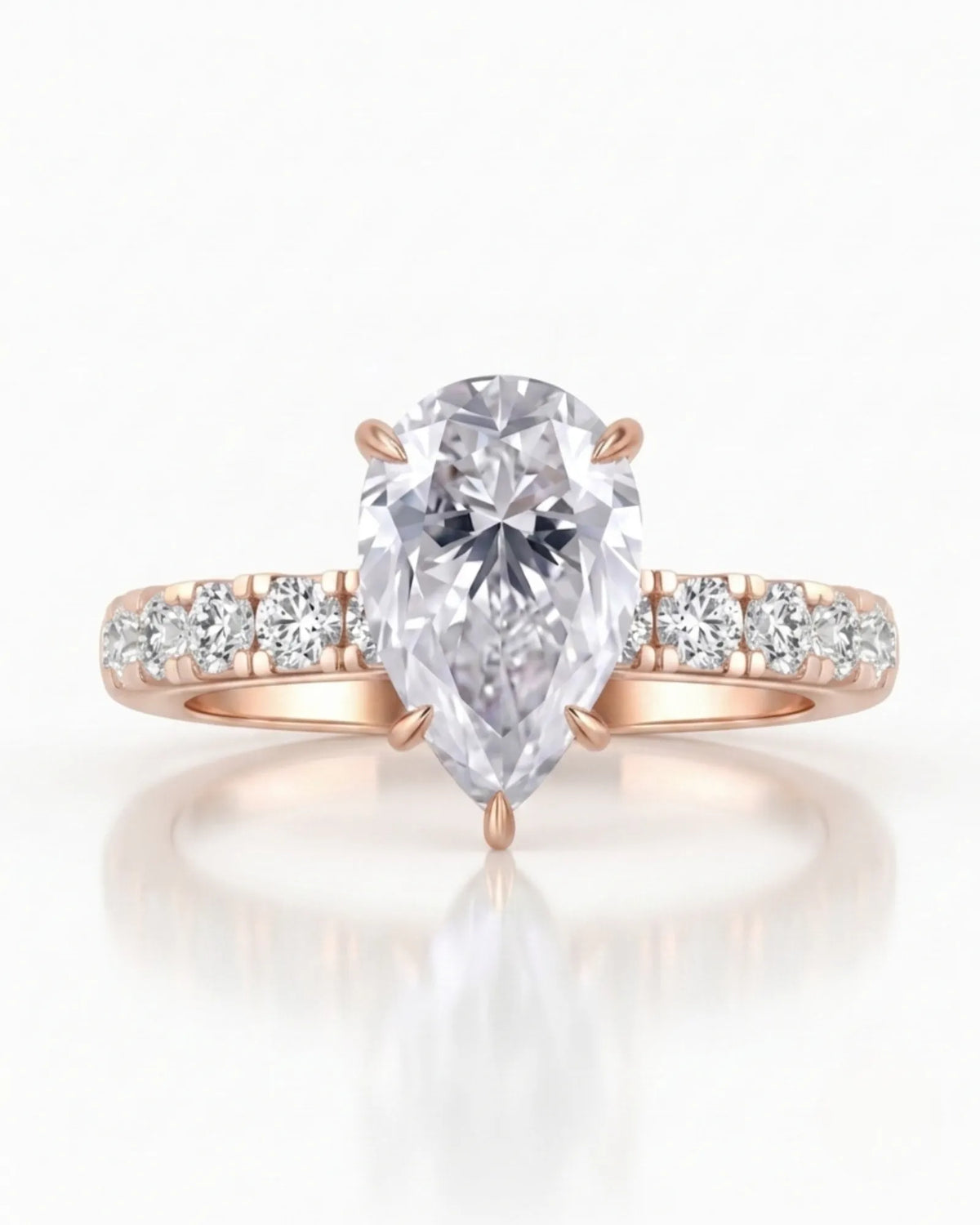 Sculptural pear moissanite ring with hidden halo and accented shoulders in polished 18K rose gold | SARATTI