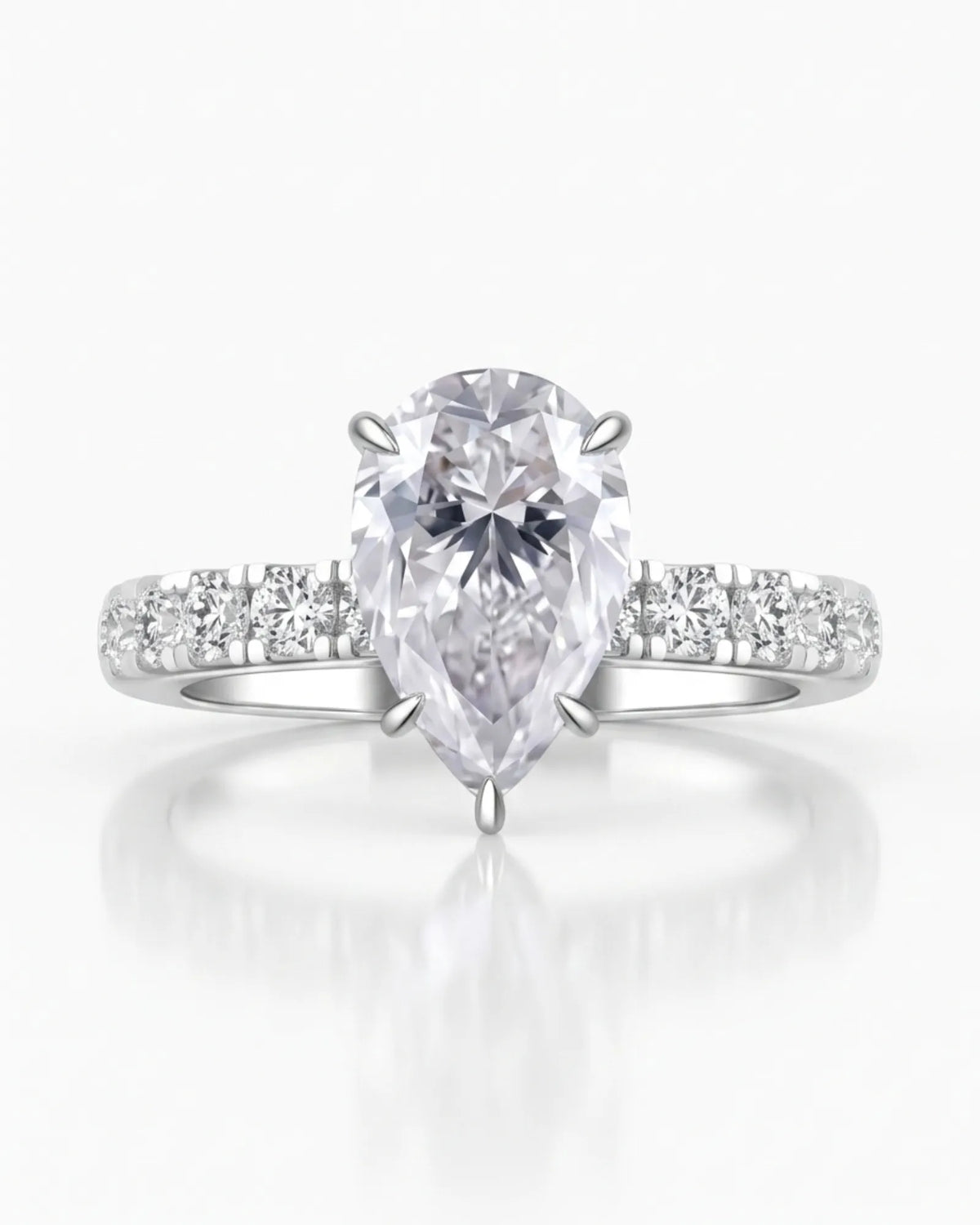 Sculptural pear moissanite ring with hidden halo and accented shoulders in polished 18K white gold | SARATTI