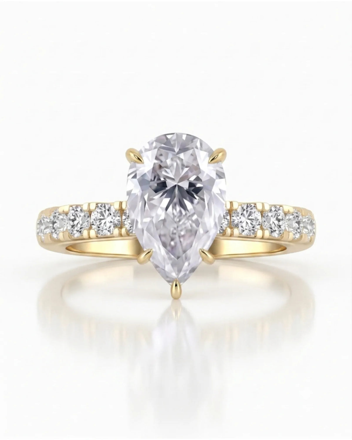 Sculptural pear moissanite ring with hidden halo and accented shoulders in polished 18K yellow gold | SARATTI
