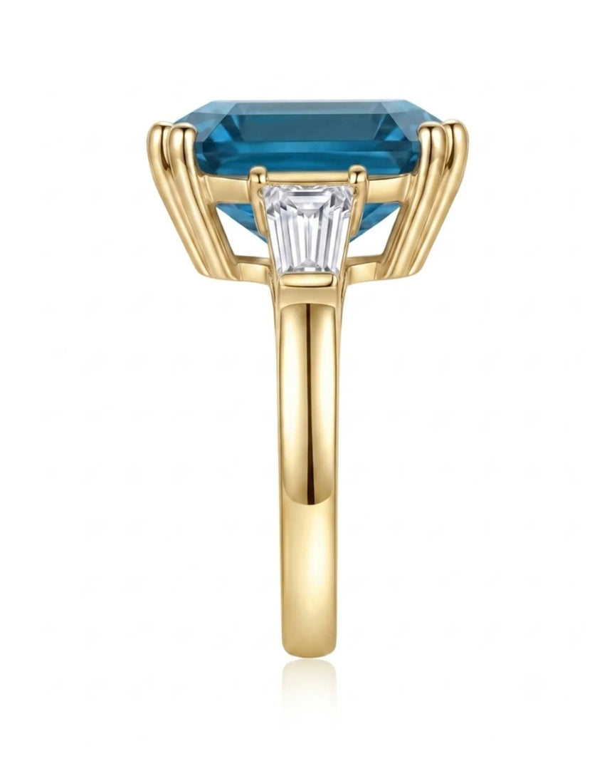 Three-stone blue topaz engagement ring with architectural baguette accents in 18K yellow gold | SARATTI