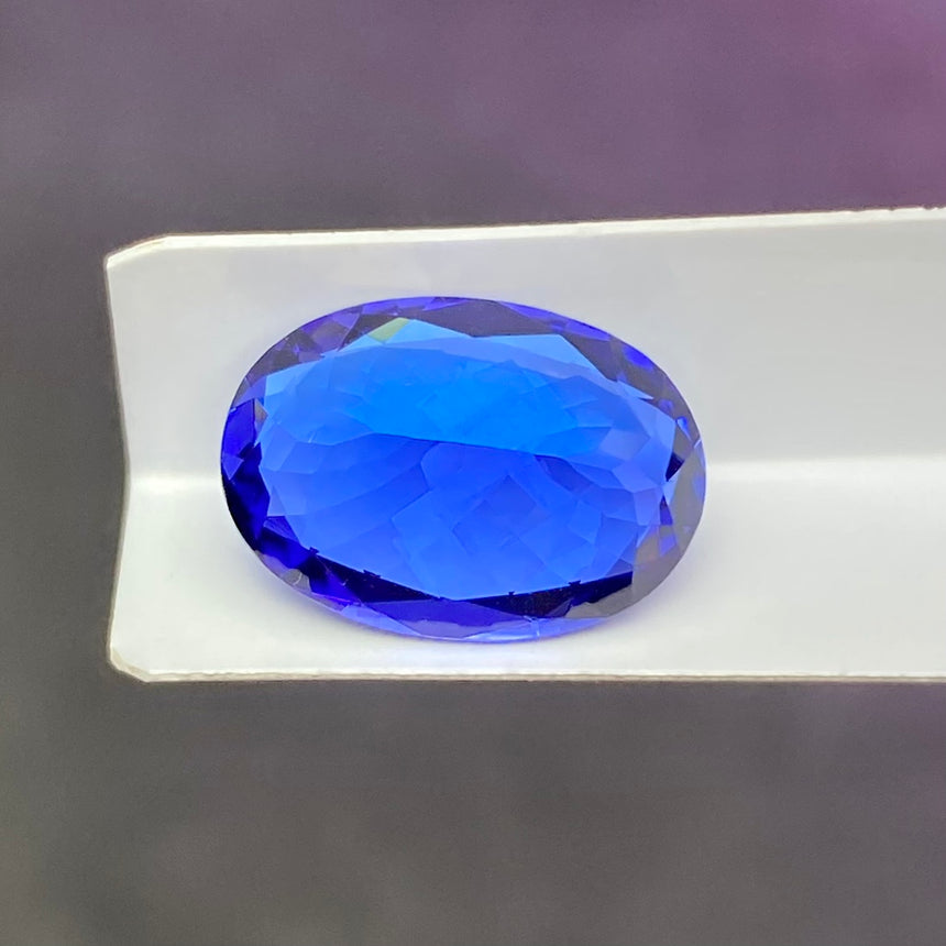 Vivid blue oval tanzanite 6.25ct viewed side angle loose gem | SARATTI