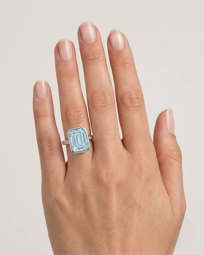 AUREX emerald cut Aquamarine bezel ring setting in Platinum, shown on hand | SARATTI