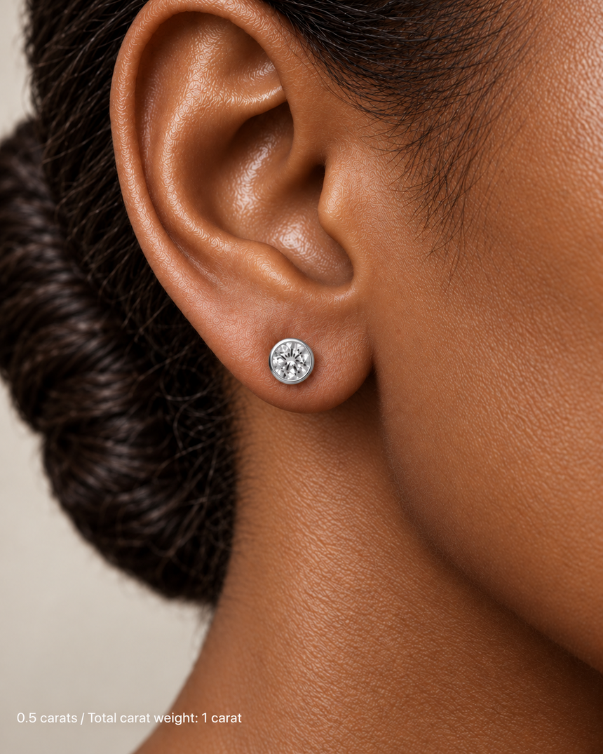 1.00 ct. tw. lab-grown round diamond full-bezel studs in 14K white gold on deep skin | SARATTI