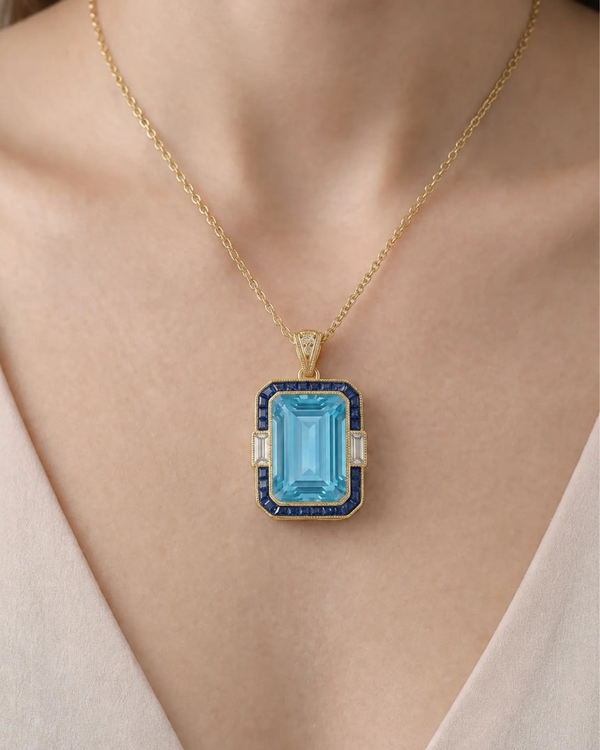 Bleu Meridian emerald-cut Aquamarine sapphire and diamond necklace setting in yellow gold, worn at the neckline | SARATTI