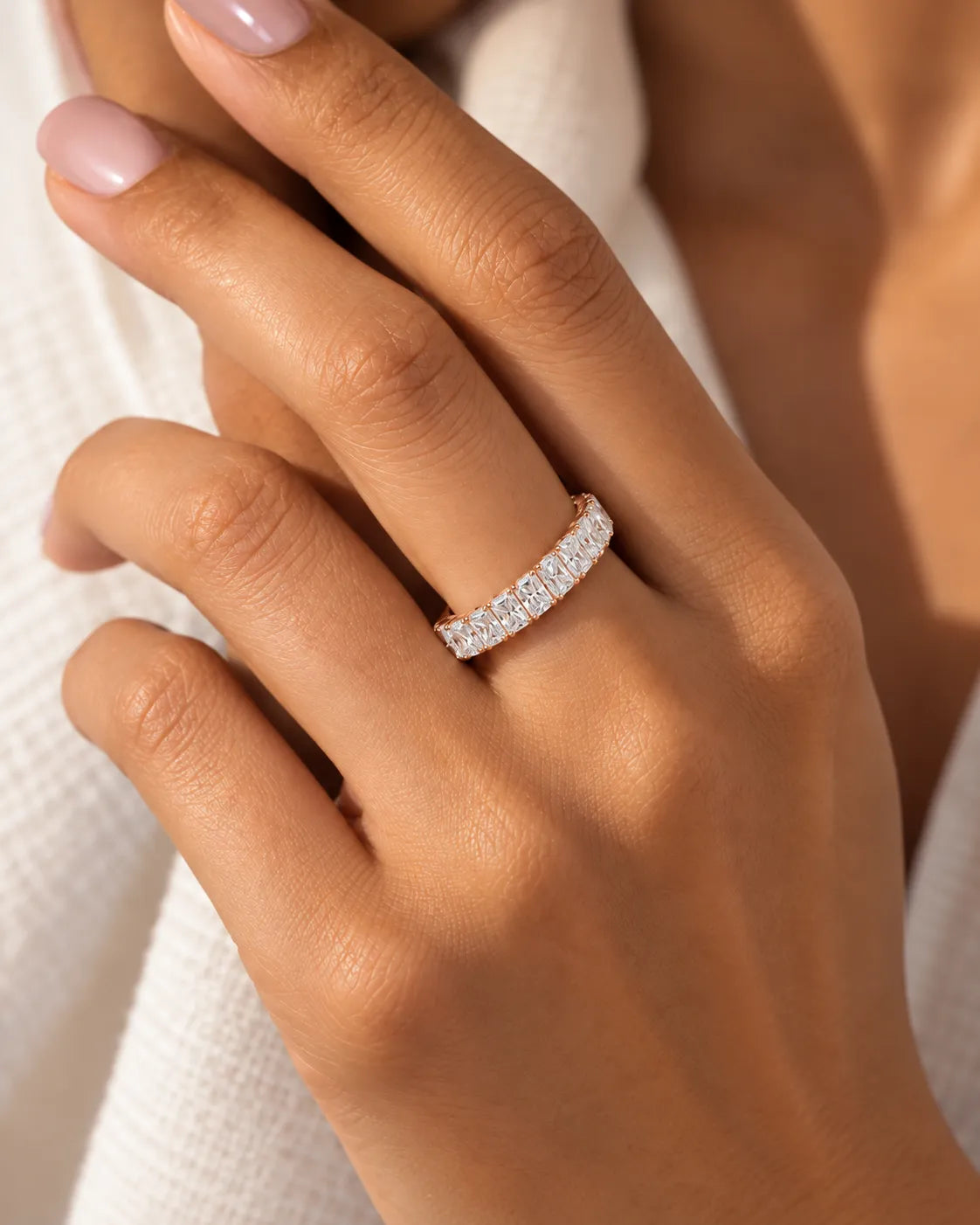 Radiant cut diamond eternity band in 18K rose gold worn on model | SARATTI