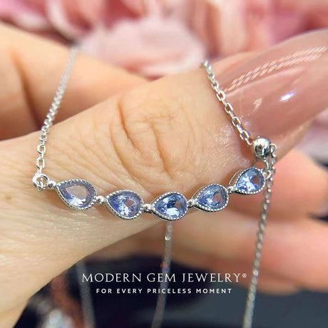 Model holds the Wisteria Teardrop Tanzanite Necklace | Modern Gem Jewelry | Saratti