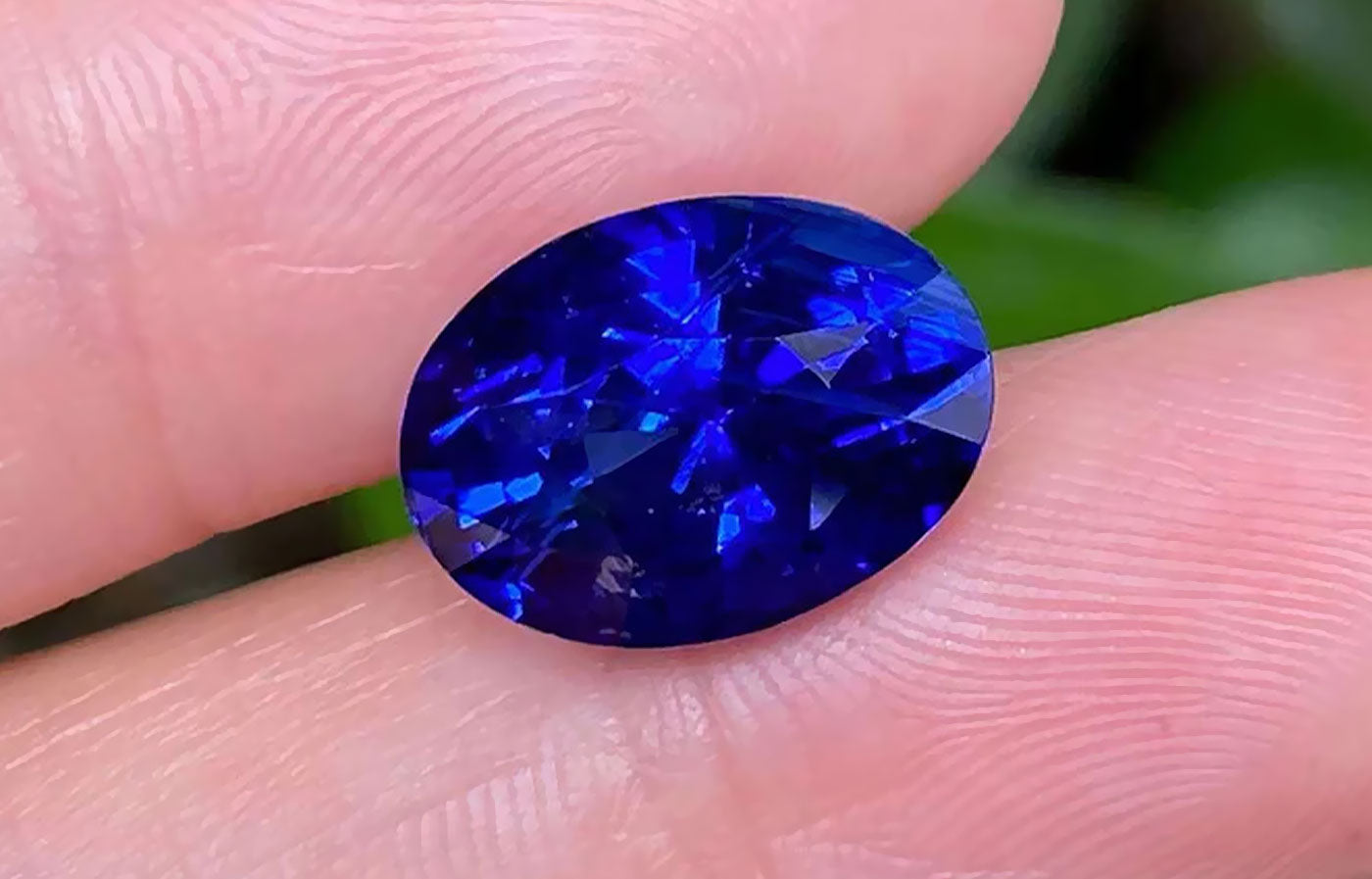 Gorgeous Blue Sapphire between fingers - From the Earth to Your Jewelry Box - The Story of Virgo's September Birthstone - Saratti 