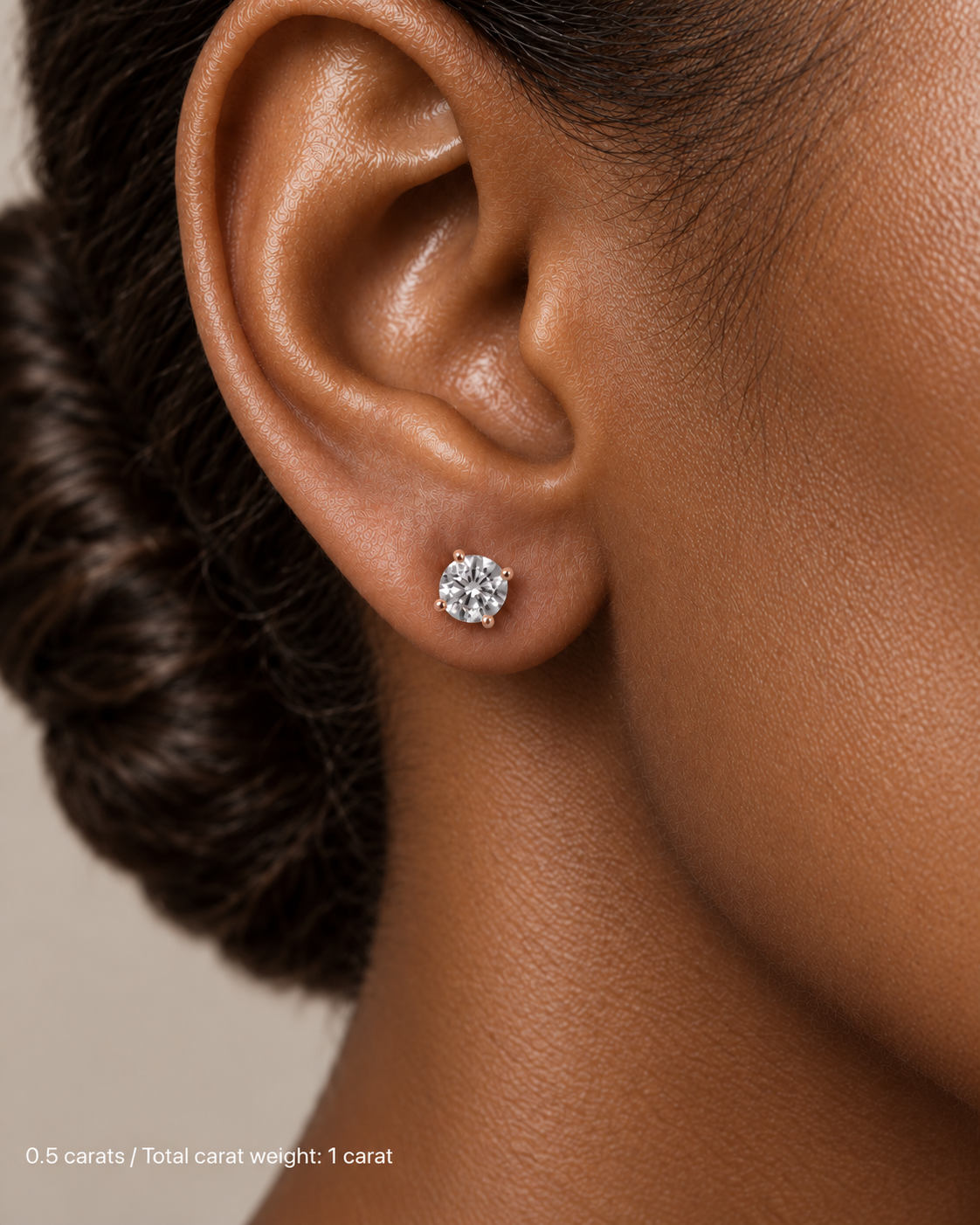 1.00 ct. tw. lab-grown round diamond studs in 14K rose gold, deep skin on-ear model | SARATTI