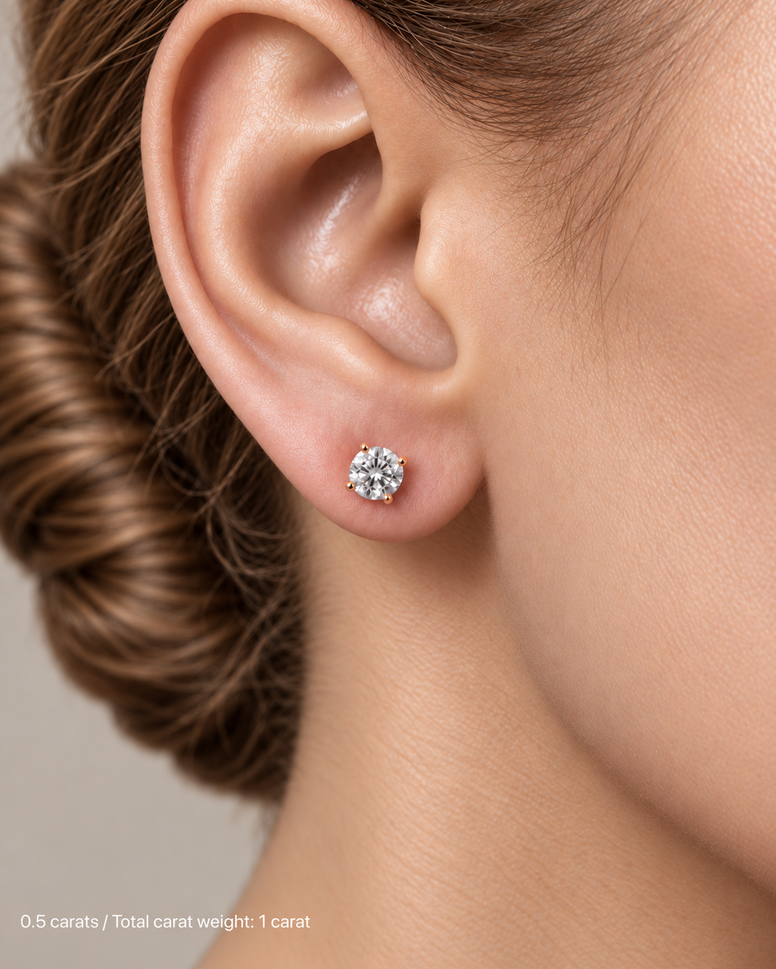 1.00 ct. tw. lab-grown round diamond studs in 18K rose gold, fair skin on-ear model | SARATTI