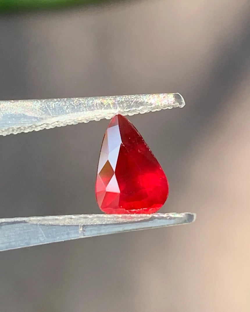 Additional view of 1.01 CTS Natural vivid red pear-shaped Ruby showing its pointed outline and red body colour | SARATTI