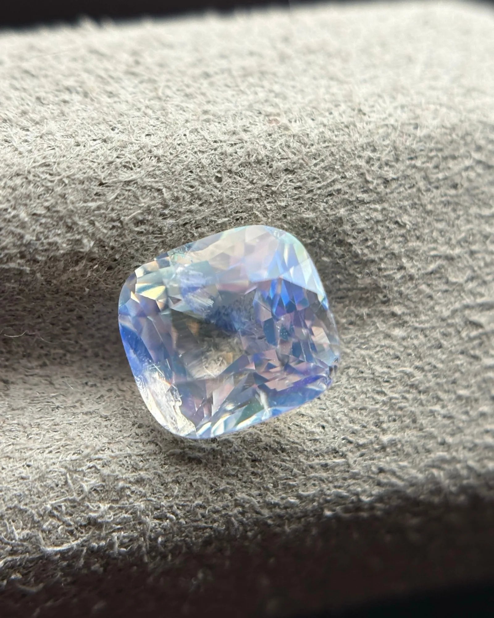 Natural Rainbow Moonstone cushion alternate face-up view with blue and softer violet reflections through the facets | SARATTI