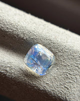 Natural Rainbow Moonstone cushion at an oblique angle showing blue sheen, rounded corners and faceted proportions | SARATTI