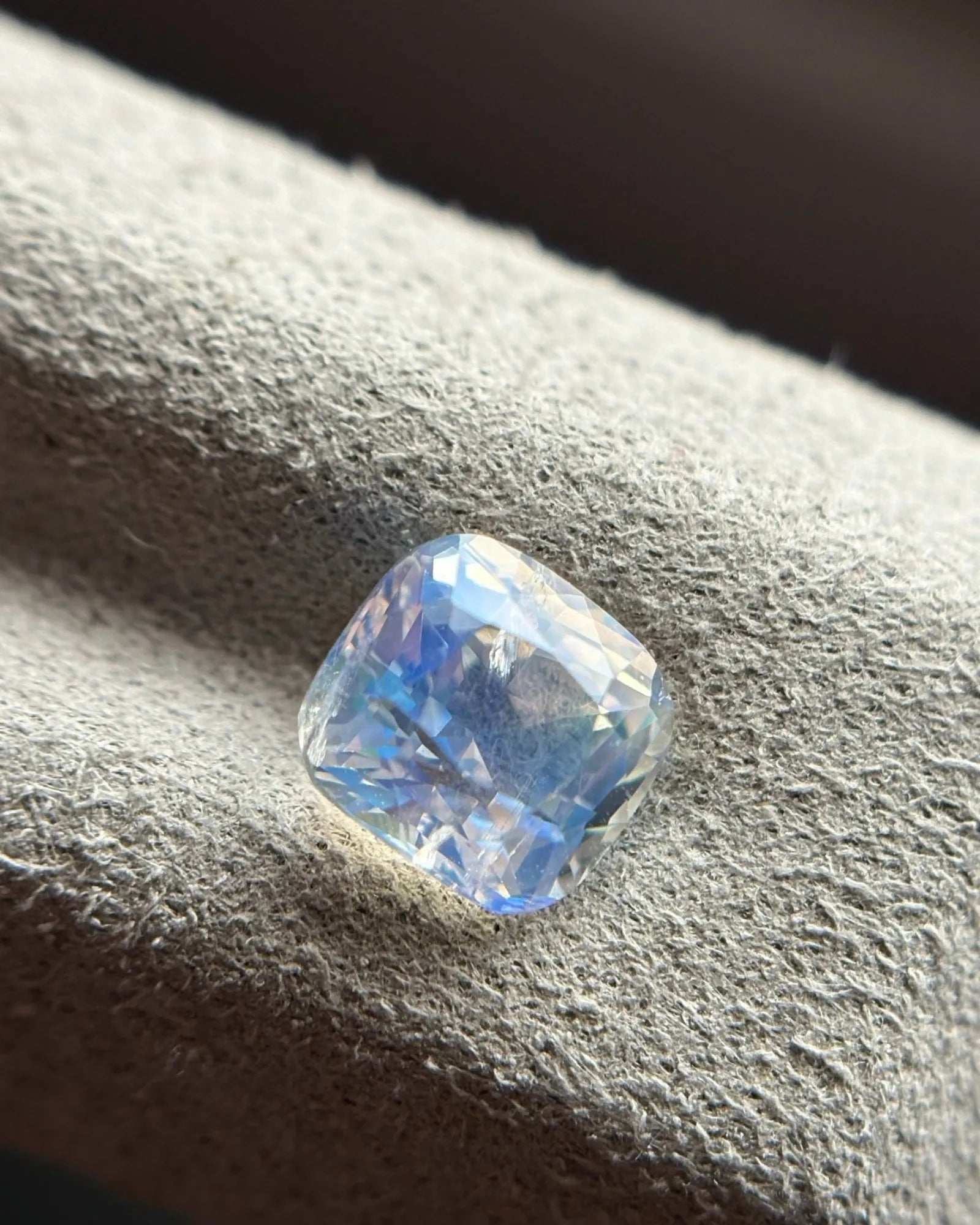 Natural Rainbow Moonstone cushion at an oblique angle showing blue sheen, rounded corners and faceted proportions | SARATTI