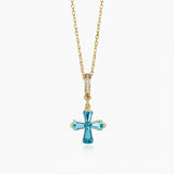 Gold necklace with a blue gemstone cross pendant on a white background | SARATTI - Natural Aquamarine Necklace in 18K Yellow Gold