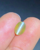 Close-up of 2.23 carat Yellowish Green Cat's-Eye Chrysoberyl showing a concentrated chatoyant band across the oval cabochon