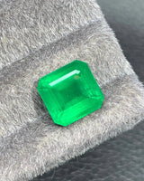 Close-up of a 4.95 CTS Vivid Green Natural Emerald showing broad step-cut facets and geometric light reflections | SARATTI