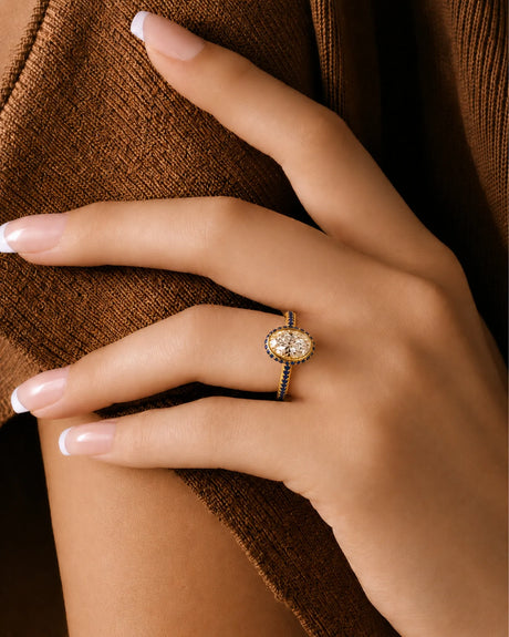 Bezel-set oval moissanite ring with sapphire gallery accents and slim 18K yellow gold shank | SARATTI