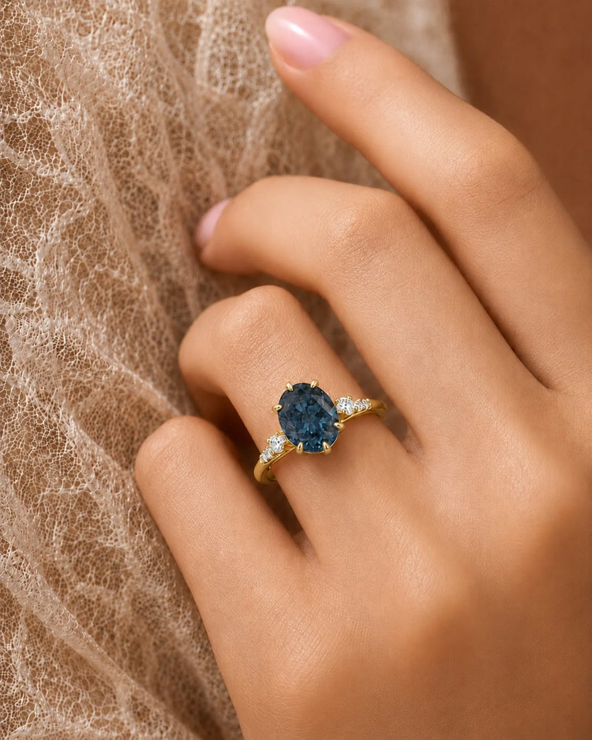 Blue moissanite ring with sculptural prong setting and warm yellow gold band | SARATTI