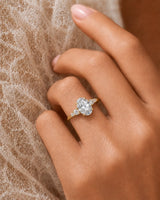 Classic five stone moissanite ring with oval center and sculptural prongs in yellow gold | SARATTI