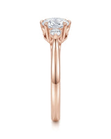 Classic round moissanite ring with two side stones in polished 18K rose gold | SARATTI