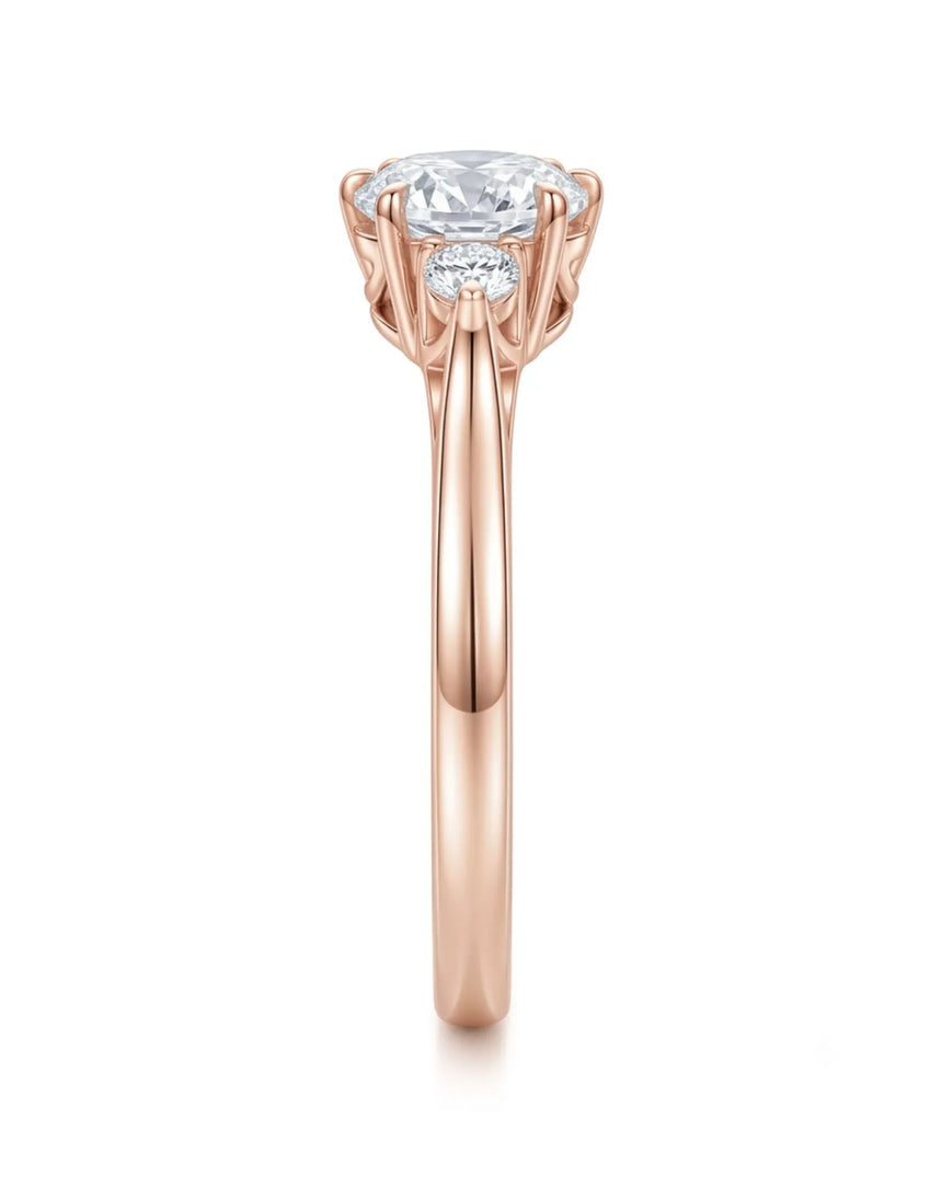 Classic round moissanite ring with two side stones in polished 18K rose gold | SARATTI