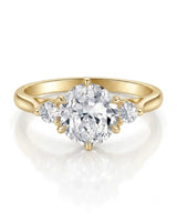 Classic round moissanite ring with two side stones in polished 18K yellow gold | SARATTI