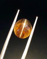 Close-up of 5.00 carat oval Cat's-Eye Chrysoberyl showing a concentrated central light band across its brown body