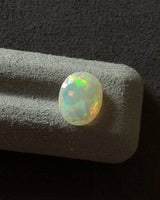 Close-up of Ethiopian White Opal showing vivid orange and green play-of-colour | SARATTI