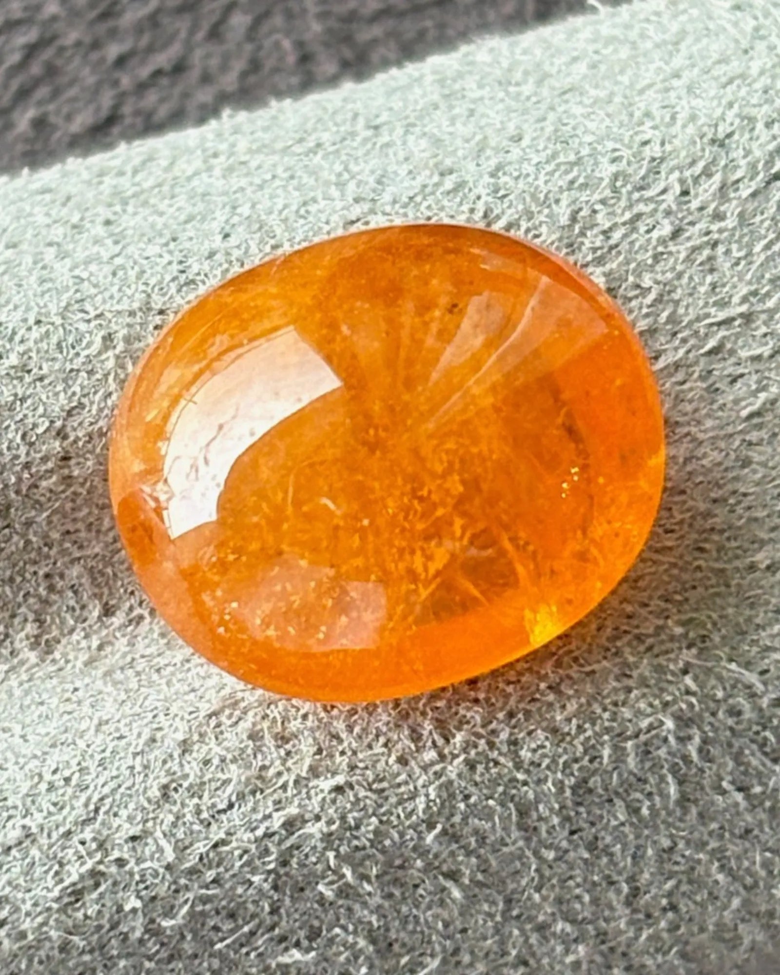 Close-up of Namibian orange Garnet polished cabochon surface | SARATTI