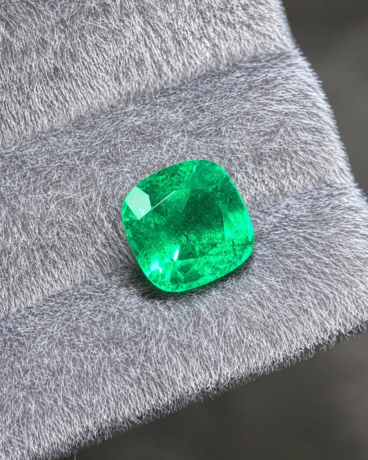 Close-up of modified brilliant facets on a vivid green Emerald | SARATTI