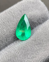 Close-up of modified brilliant facets on a vivid green pear Emerald | SARATTI