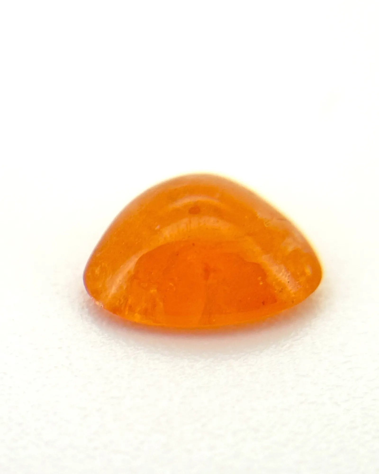 Close-up of orange Garnet polished cabochon surface | SARATTI