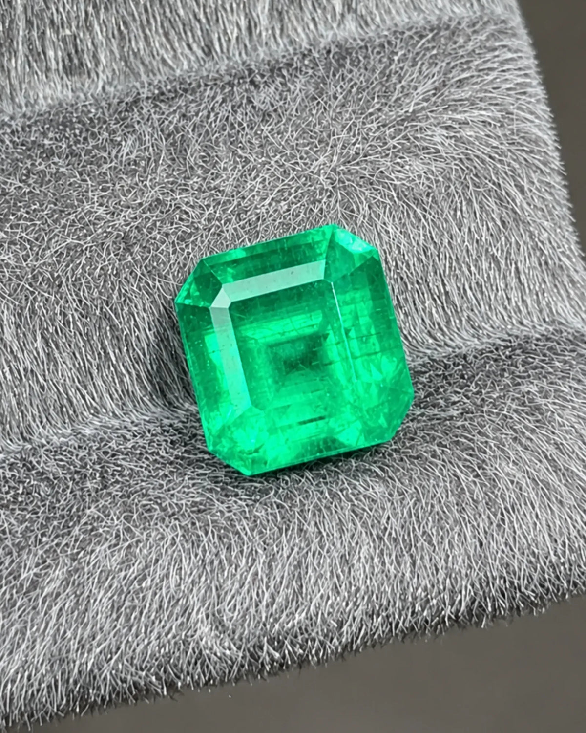 Close-up of ordered step facets on a vivid green Natural Emerald | SARATTI