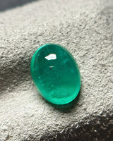 Close-up of polished green Emerald cabochon surface | SARATTI